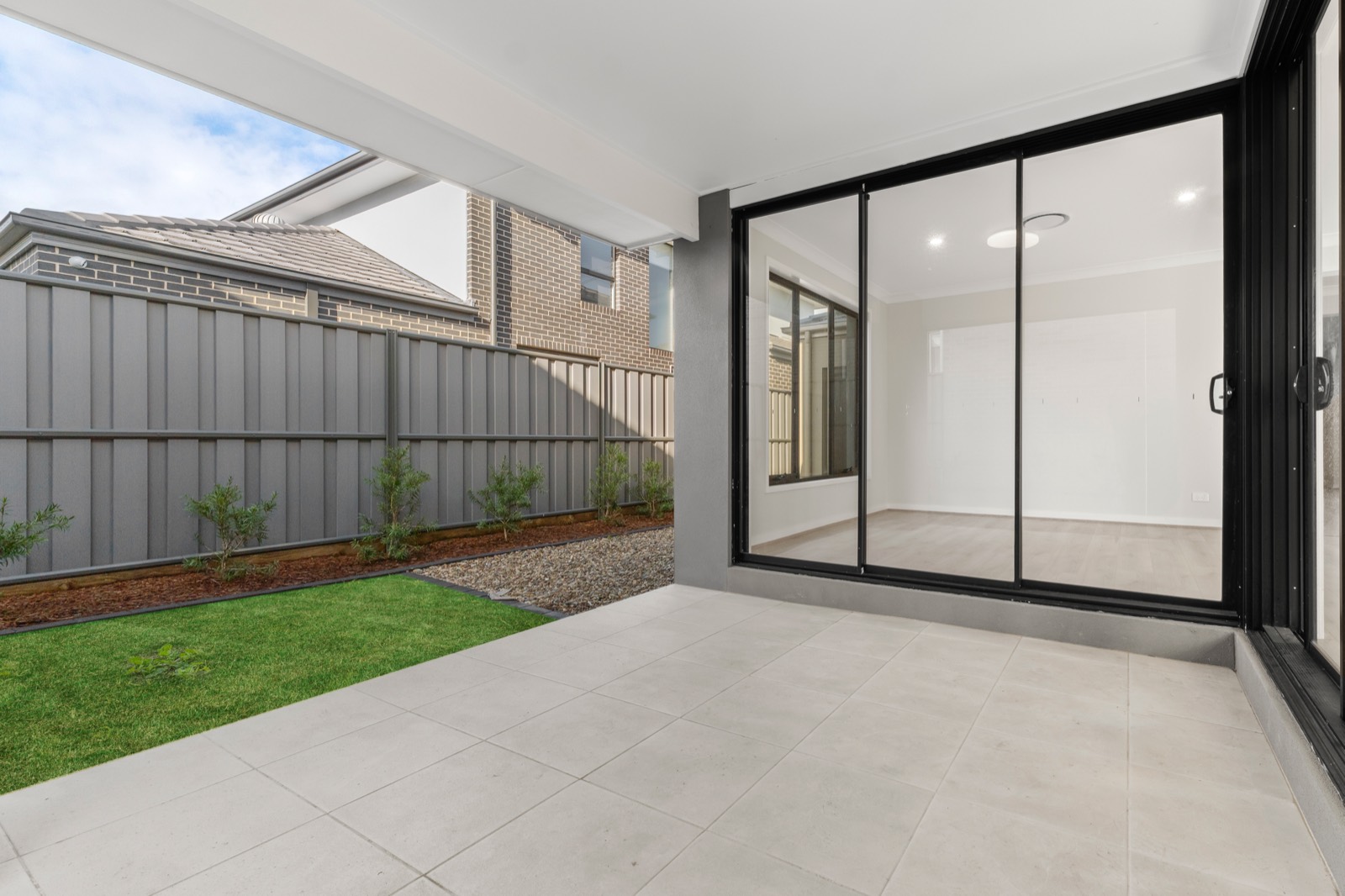Covered alfresco area opening onto a landscaped backyard