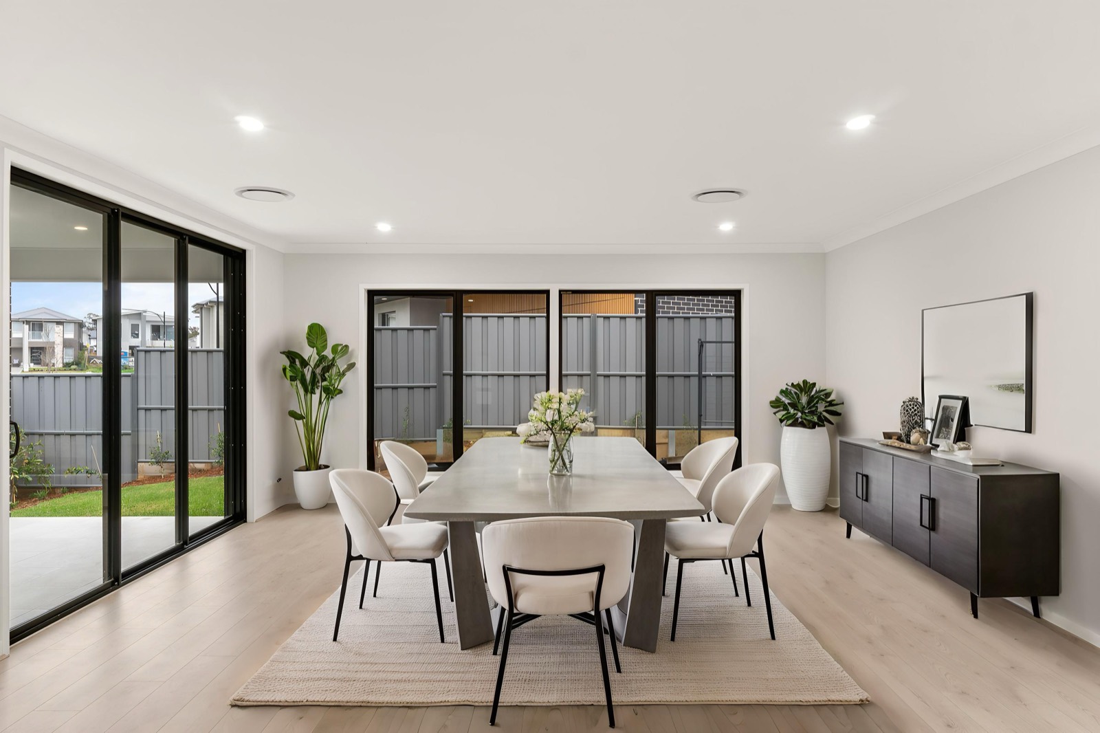 Dining room with a timber table, designer chairs and a garden outlook