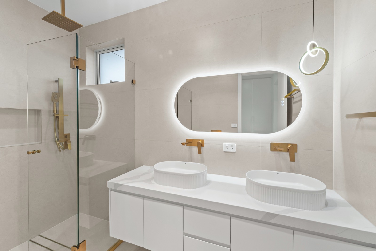 Modern ensuite with a frameless glass shower and stone vanity