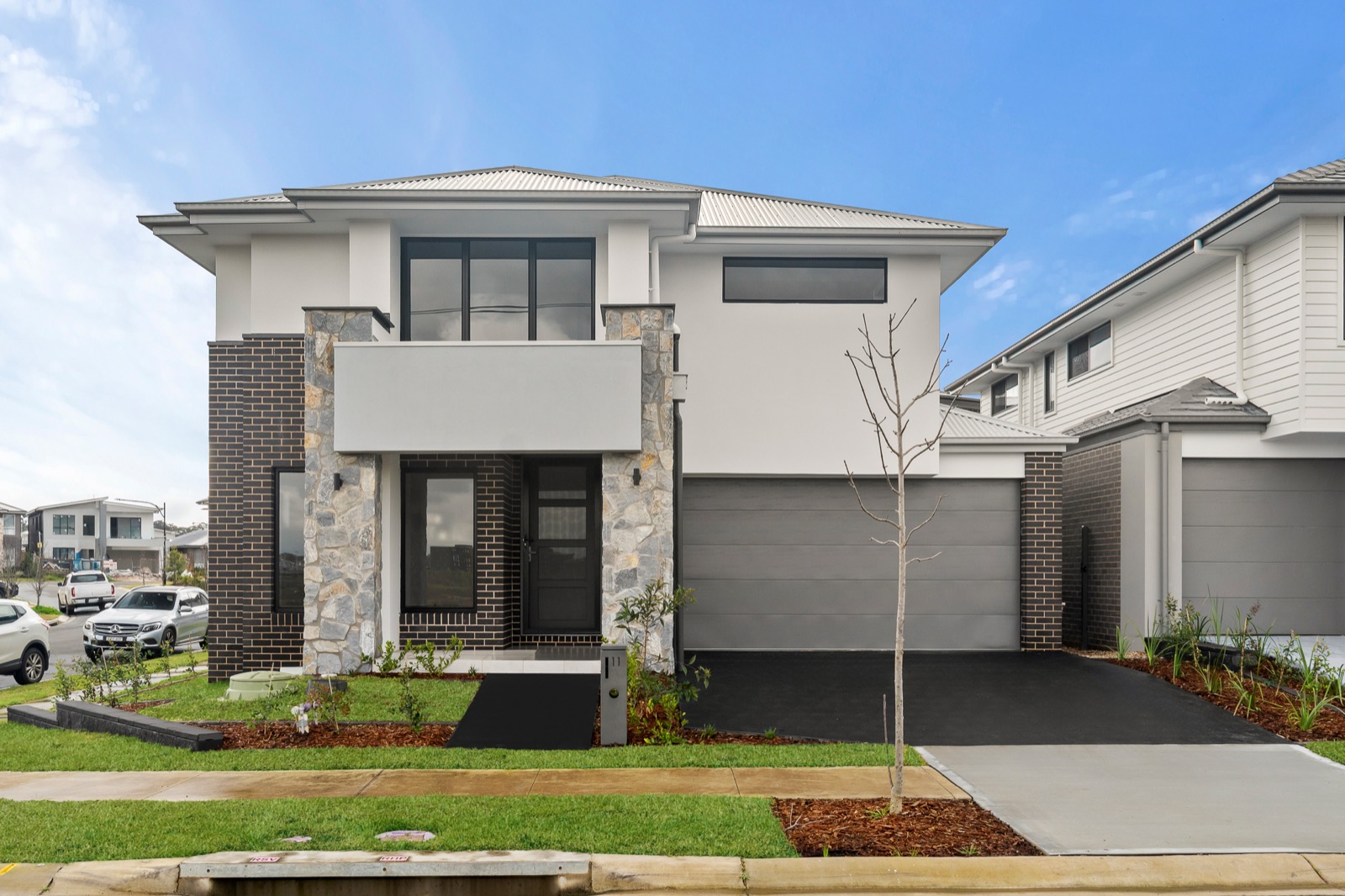 Contemporary two-storey home with stone-clad portico and steel-grey roofline